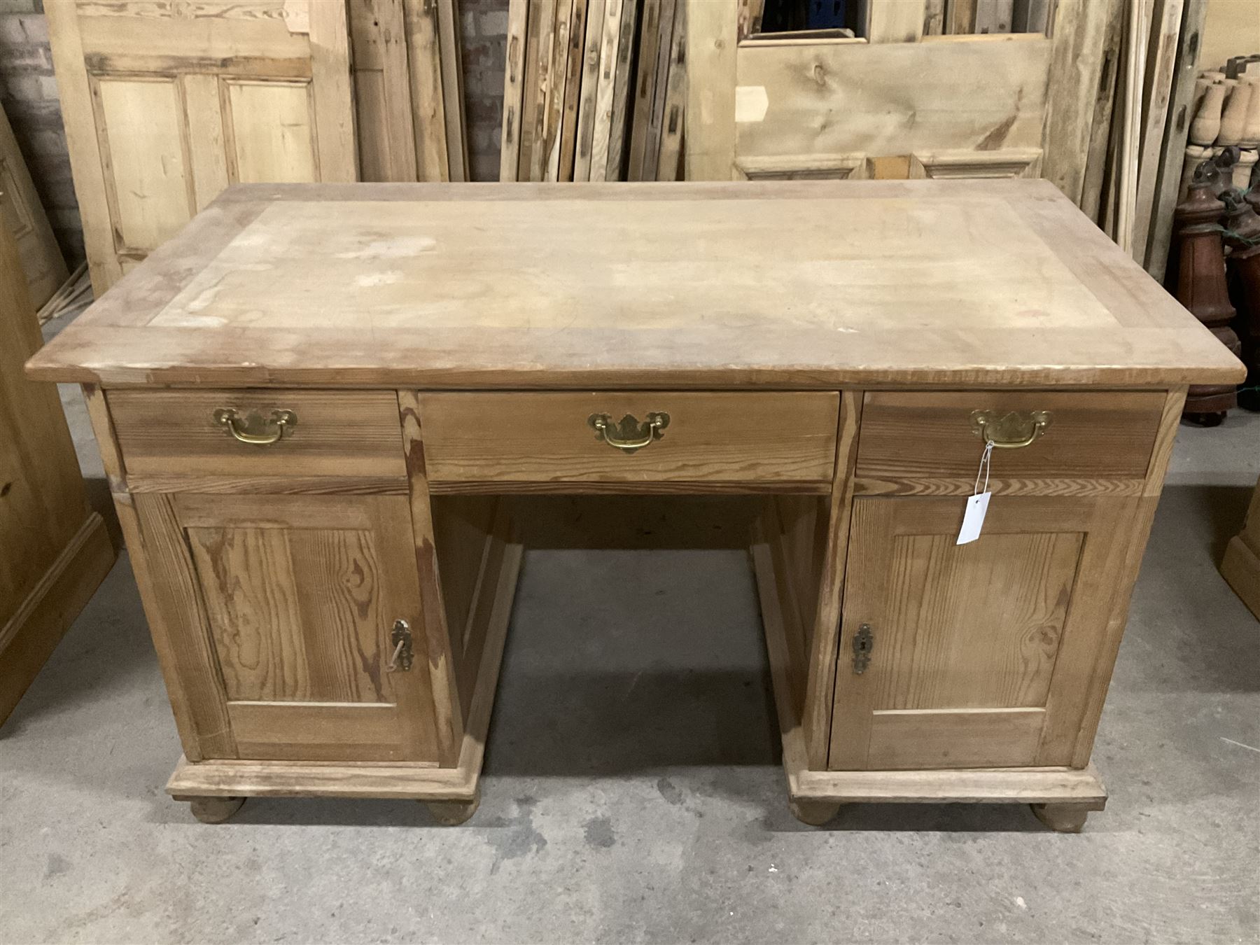 20th century pine twin pedestal desk, rectangular top over three drawers and two cupboards, enclosed by panelled doors, on turned feet - THIS LOT IS TO BE COLLECTED BY APPOINTMENT FROM THE OLD BUFFER DEPOT, MELBOURNE PLACE, SOWERBY, THIRSK, YO7 1QY