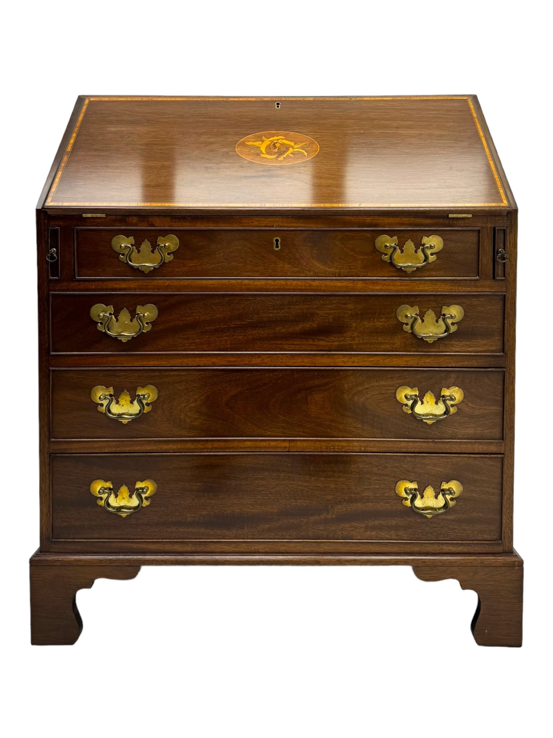 Mid-to-late 20th century inlaid mahogany bureau, inlaid floral medallion to the top, the fall front opening to reveal fitted interior with pigeonholes, small drawers and central cupboard, green inset writing surface with gilt tooling, four drawers below with brass handles, raised on shaped bracket feet