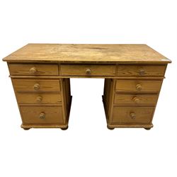 Waxed pine twin pedestal desk, rectangular top over nine drawers, on compressed bun feet 