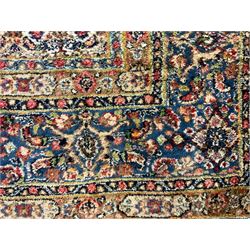 Persian indigo ground rug, the ivory field decorated with all-over flower heads, heavily guarded border with repeating stylised plant motifs