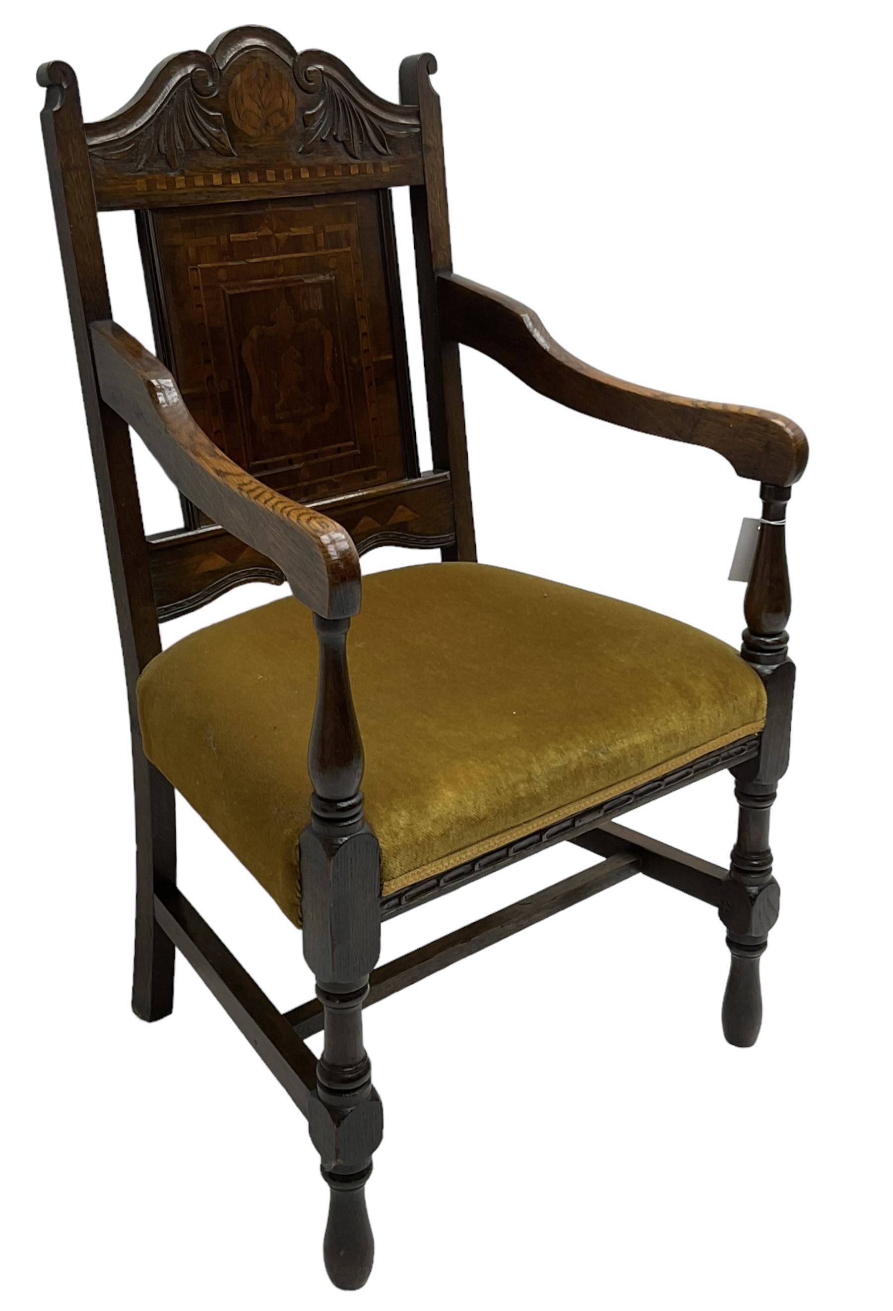 Late 19th to early 20th century oak elbow chair, the shaped cresting rail carved with scrolls and foliage, panelled back inlaid with parquetry work and central rampant lion within shield, upholstered seat, on turned supports joined by H stretchers