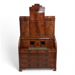 19th century Biedermeier figured mahogany cylinder bureau cabinet, the raised super structure with stepped pointed pediment over hidden cupboard and hinged fall front, the interior fitted with pigeonholes and secret drawers behind rusticated inlay, curved flanking cupboards fitted with internal drawers, the cylinder top opens to reveal small drawers, document divisions and secret compartments, sliding desk with central hinged writing surface, inlaid with satinwood bands and draped festoons, fitted with three long drawers, on bracket feet