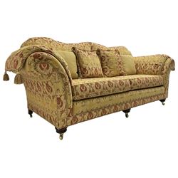 Steed Upholstery Ltd. - 'Lincoln' three-seat sofa upholstered in gold 'Olympia' floral pattern corded and tasselled fabric, together with scatter cushions and arm covers, on turned feet with brass castors