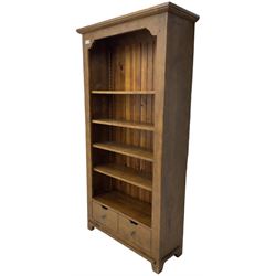 John Lewis - 'Bergerac' oak bookcase, projecting moulded cornice over four adjustable open shelves, two drawers to the base with cut-out handles, on square tapered supports