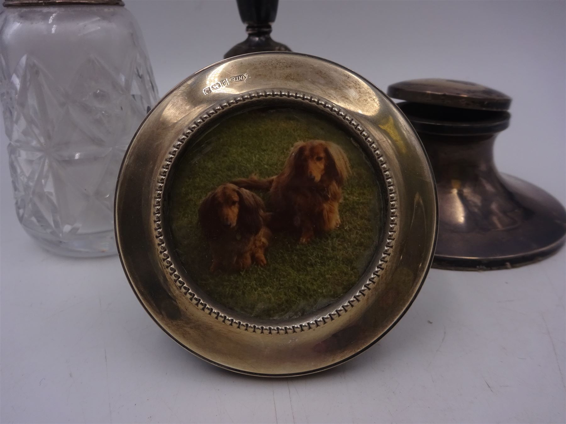 Group of silver mounted items, including cut glass sugar caster, capstan inkwell, circular photograph frame and dwarf candlestick, candlestick H11cm