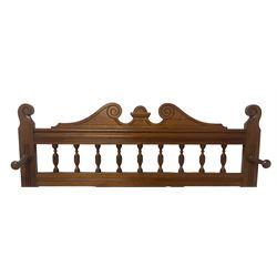 Late Victorian hallstand, raised pediment over balustrade frieze, bevelled mirror back with coat hooks over glove drawer, fitted with two drip-trays to base