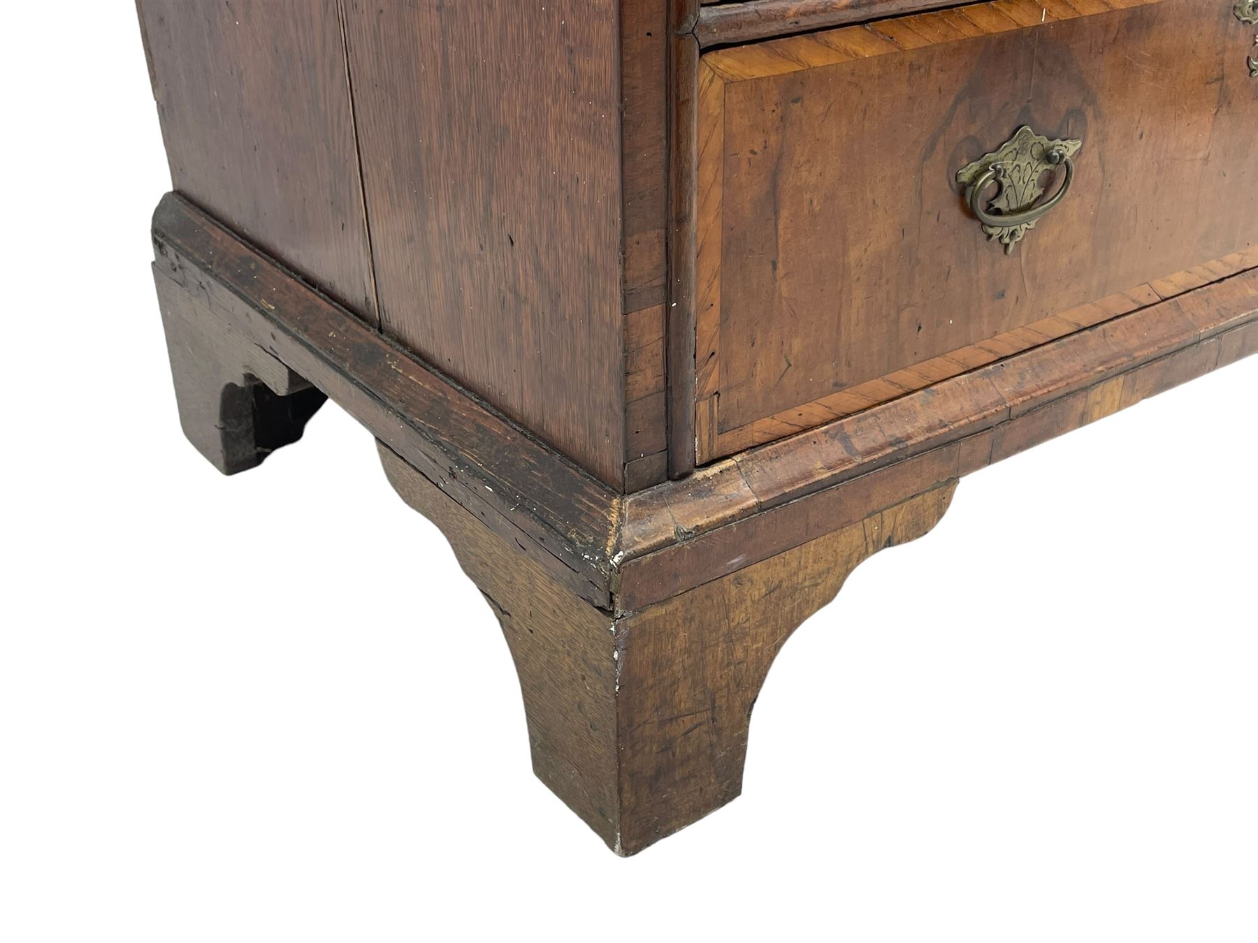 18th century oak and walnut chest, fitted with four small over three long drawers with figured walnut facias, brass handles and plates with engraved decoration, on bracket feet