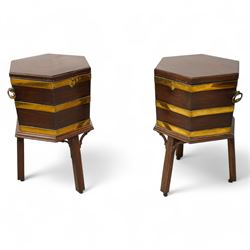 Pair of George III mahogany and brass bound cellarettes or wine coolers on stands, hexagonal form, moulded hinged lid enclosing metal lining, the body strapped in brass bands and fitted with carrying handles, the stand with moulded upper rails on splayed and moulded square supports with castors, with arched corner brackets 