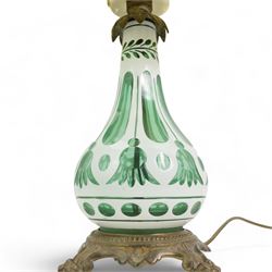 Early 20th century Bohemian green and white glass overlaid table lamp, of bulbous form with tapering neck, decorated with flower heads, with associated butterscotch mushroom form glass shade with wavy rim, on a cast brass base with four lion paw supports, H53cm