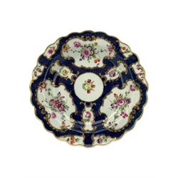 18th century Worcester tea caddy, of oval form and painted in the Kakiemon palette with reserves of flowers against a blue scale ground, H14cm together with a similar Worcester circular dish, painted with floral sprays, within a scalloped edge, blue crescent mark beneath, D19cm (2)