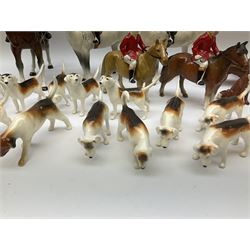 Beswick Hunting Group, comprising: two huntswoman on grey horses, model no 1730, huntsman on a bay horse, model no 1501, a seated fox, model no 1748, eighteen fox hounds and a spaniel, model no 967, all with printed marks beneath, together with three other ceramic huntsman on horseback and two hounds. 