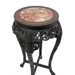 Early 20th century Chinese hardwood plant stand, circular top with marble inset, carved and pierced with interlacing foliage, on leaf carved supports united by x-framed stretchers