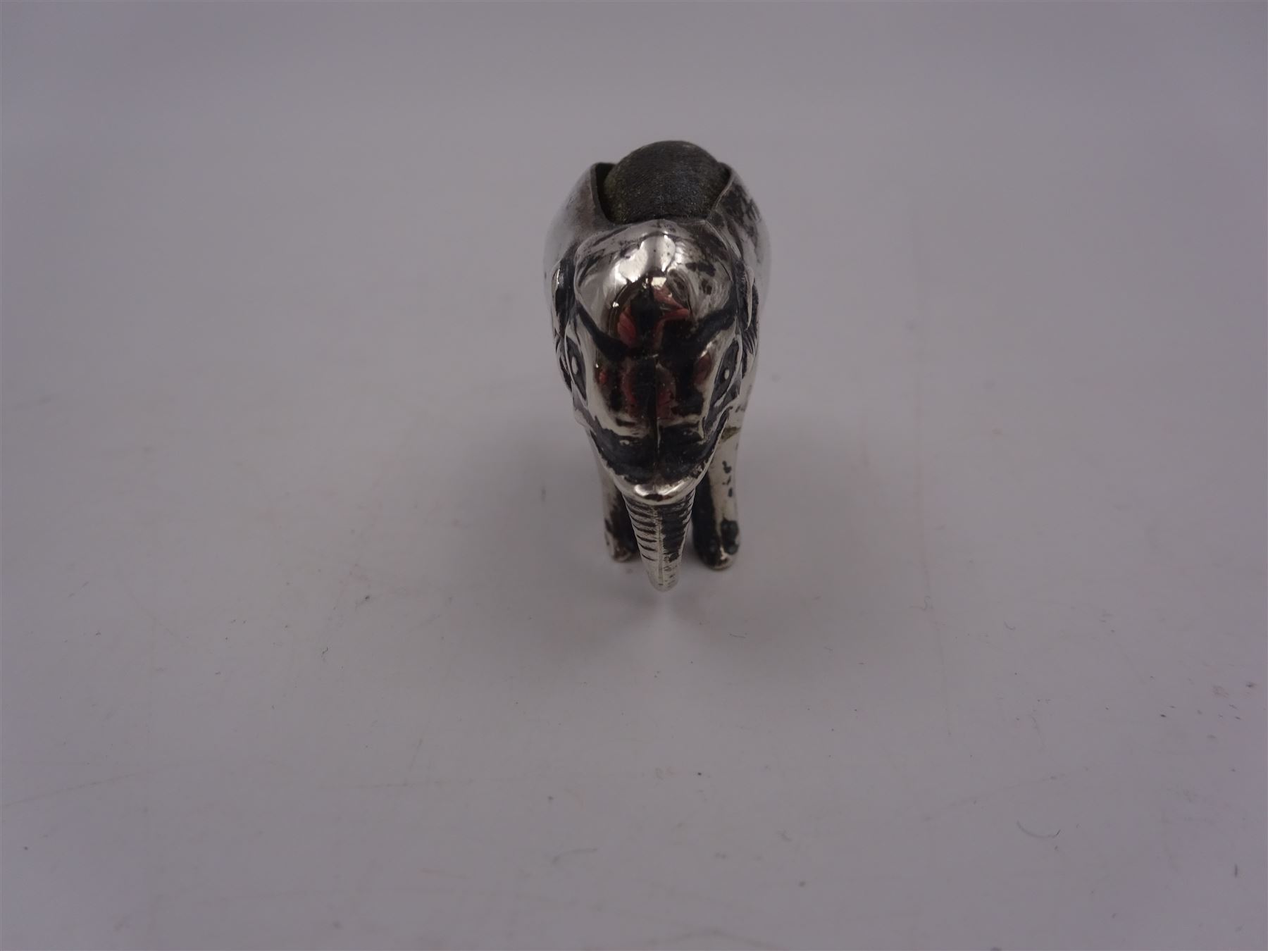 Edwardian silver mounted novelty pin cushion, in the form of an elephant, with cushioned back, hallmarked Birmingham 1906, maker's mark worn and indistinct, L4cm, H3.5cm