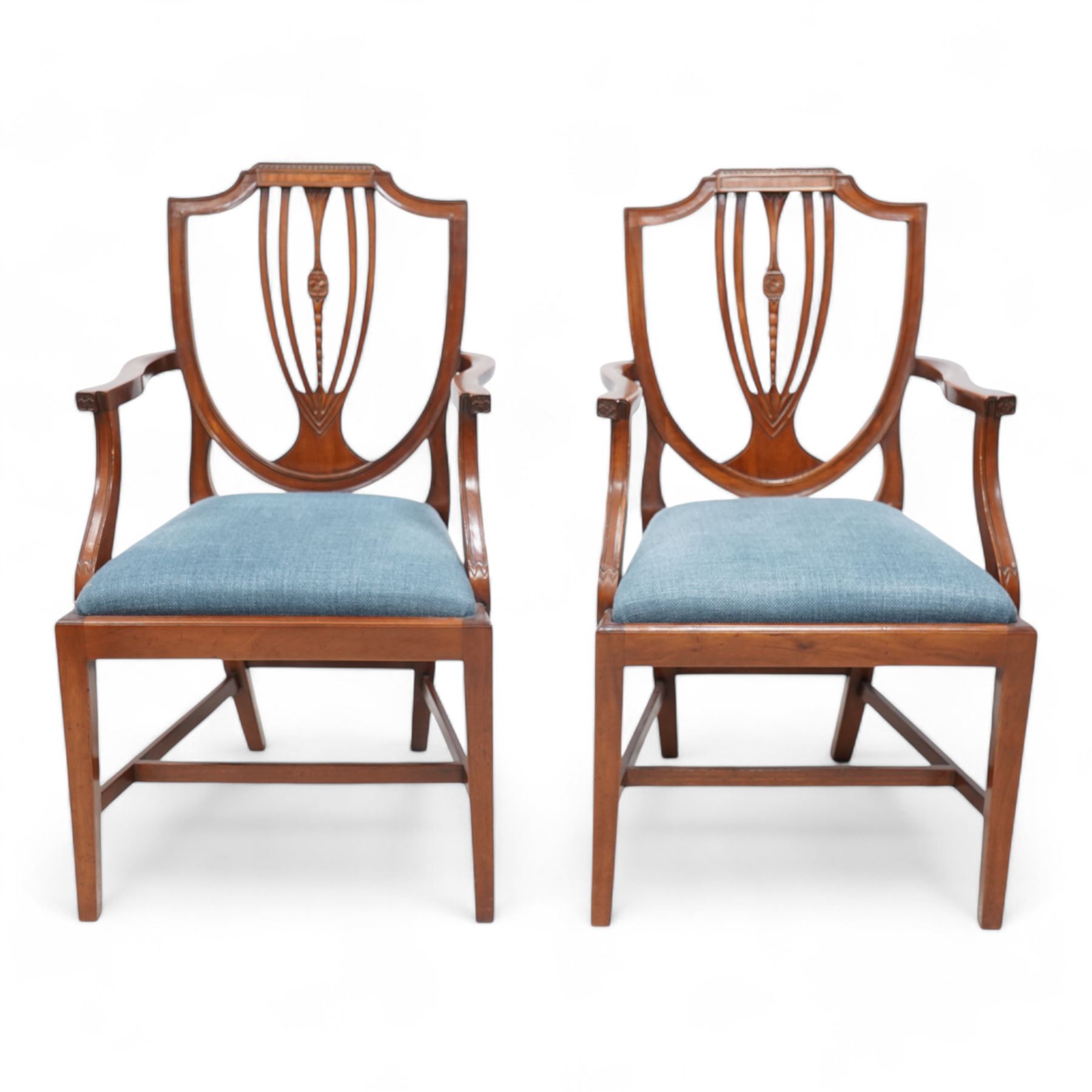 Set of twelve (10+2) Hepplewhite Revival mahogany dining chairs, moulded shield back with satinwood band, drop-in seat upholstered by Peter Silk of Helmsley, on square tapering supports united by H-stretchers 