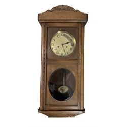 Two train oak cased wall clock, striking the hours on a coiled gong. With pendulum and key.