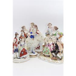 Group of Continental figures, to include two pairs of lace examples, the first modelled as courting couples seated, she with floral encrusted lace skirts, upon oval bases, each approximate H16cm, the second modelled as two dancers with floral encrusted lace skirts and lace necklines, each approximately H16cm, a pair of figure groups also modelled as a courting couple, with spurious gold anchor mark, and a further figure group of a courting couple, possibly Volkstedt, (7)