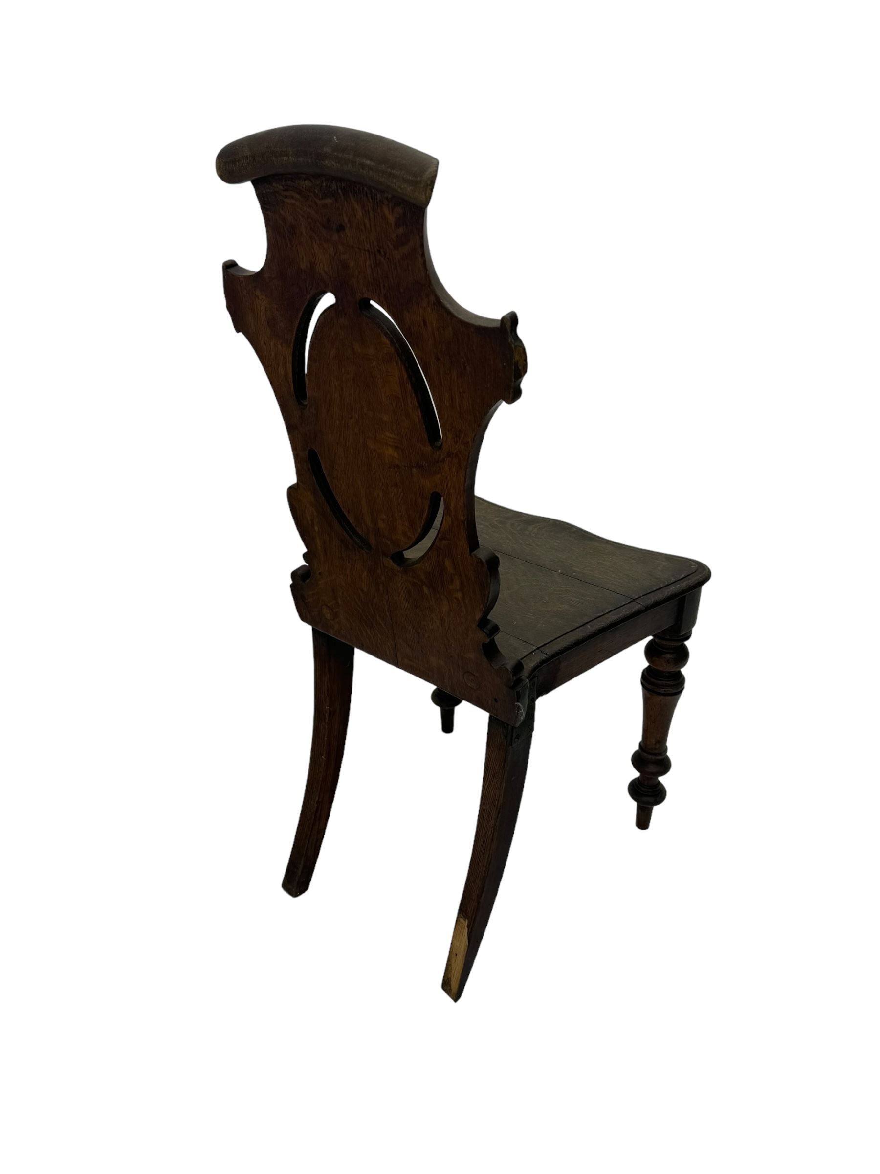 Victorian oak hall chair with scroll carved and pierced back, shaped seat and turned front supports