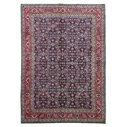 Persian Farahan indigo ground rug, the field decorated with large repeating floral herati motifs, crimson ground border decorated with palmettes and trailing leafy branch, within guard stripes 