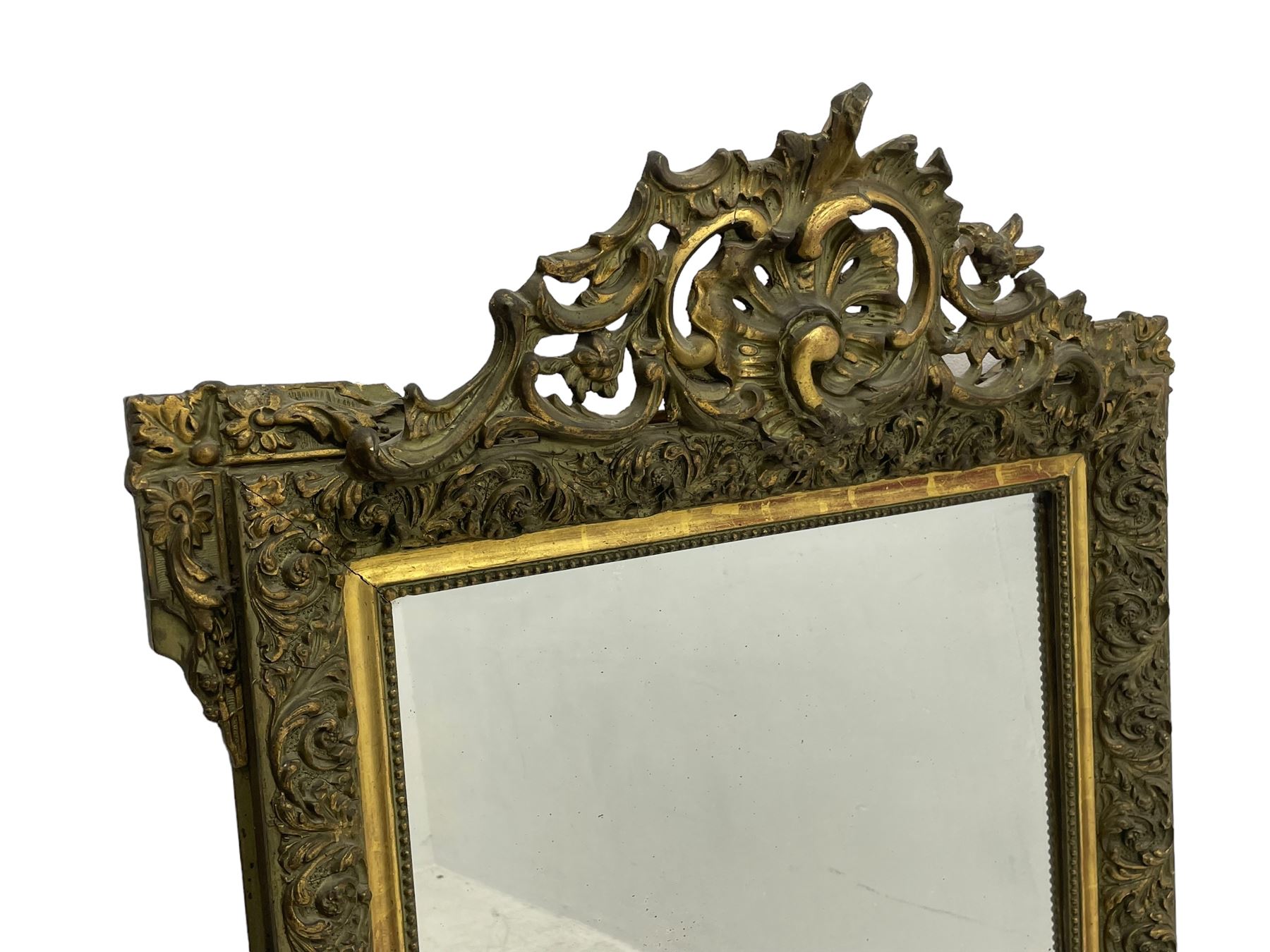 Victorian giltwood and gesso wall mirror, pierced shell cartouche pediment decorated with C-scrolls and curled leaves, moulded frame with curled acanthus leaf decoration and beaded inner slip, the corner brackets decorated with flower heads 