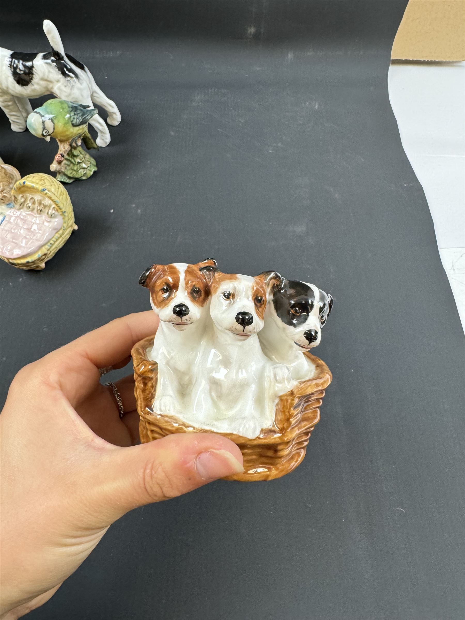 Two Royal Doulton figures of puppies in baskets, together with Beswick horse and other animal figures