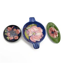 Two Moorcroft ashtrays in Magnolia pattern and Anemone pattern, together with pin dish in ...