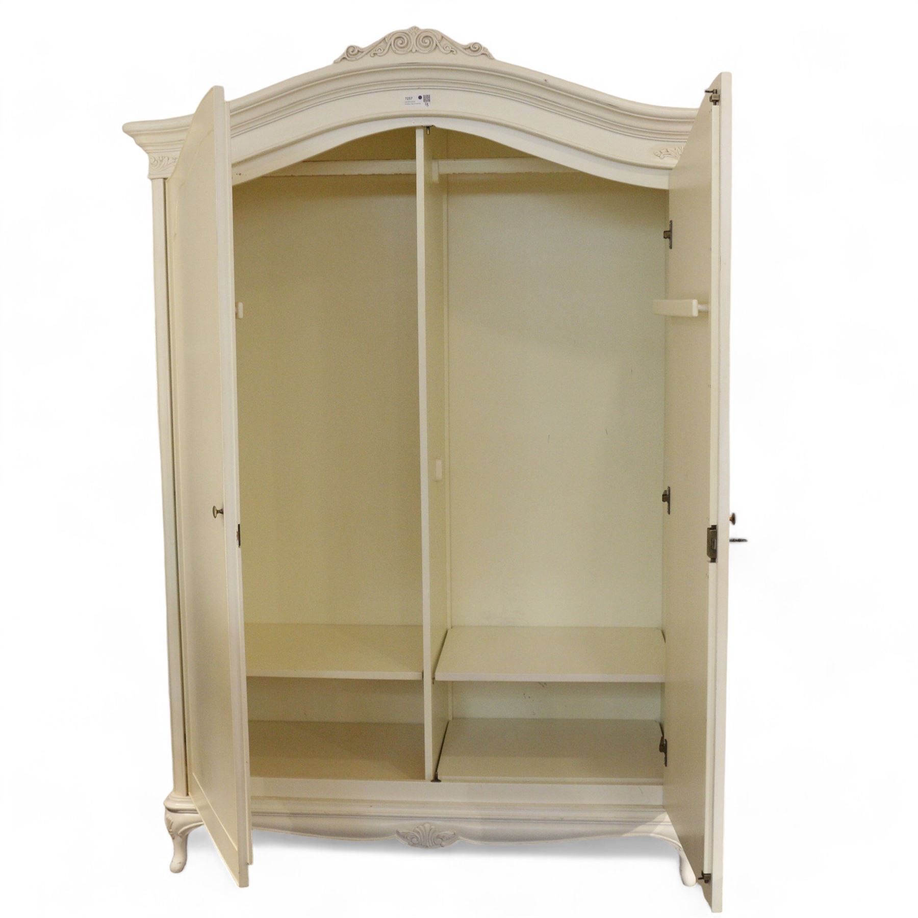 French design cream painted Armoire, foliate scroll decorated pediment over two doors, fitted with hanging rails and shelves, on cabriole feet