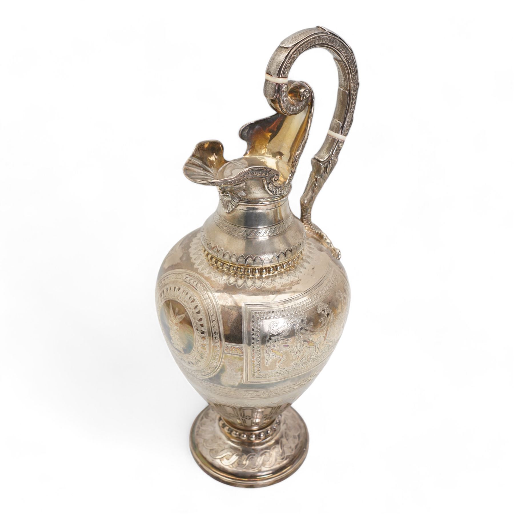 Victorian silver claret jug of baluster form engraved with Greek dithyramb panels in honour of  Dionysus, the spout with the mask of Pan, the scroll handle with birds foot terminal and with further engraved guilloche and other decoration H36cm Sheffield 1864 Maker Roberts & Belk 