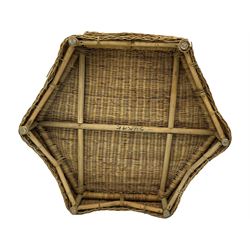 Mid-20th century hexagonal wicker coffee table, featuring woven top with pattern that radiates from the centre, lower shelf for additional storage, supported by interwoven wicker legs