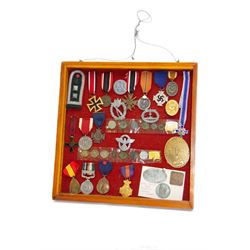 European and World medals and replicas, Italian Commemorative Cross of the 11th Army, German Cross of Honor, Pakistan 1948 general service medal, Belgium Commemorative medal, together with German coins, badges etc, all within a framed display, H29cm, W38cm 