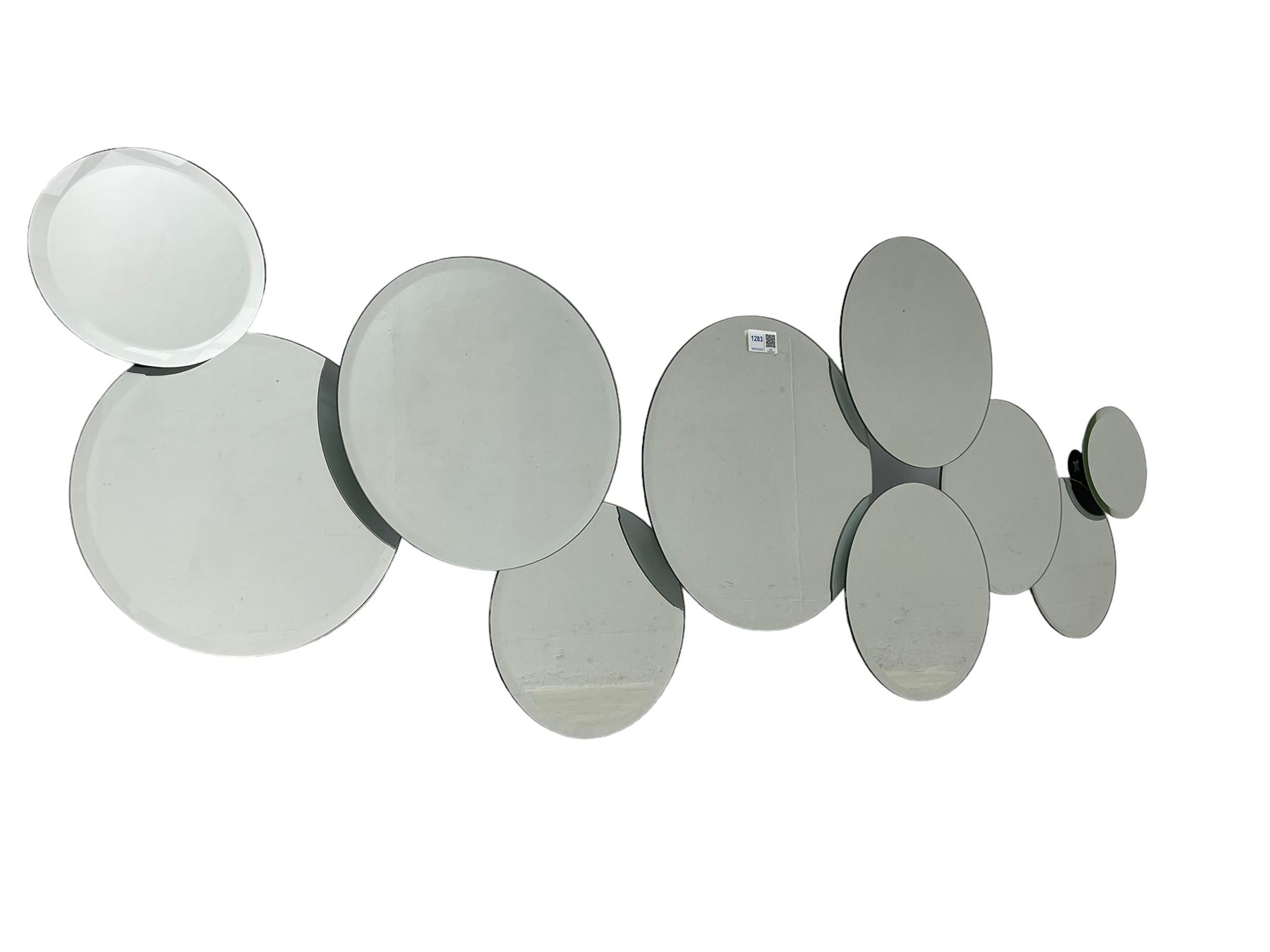 Contemporary abstract circular mirror, comprised of interconnecting bevelled plates of varying sizes