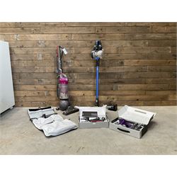 Dyson DC40 vacuum cleaner with various attachments, and a Vax cordless vacuum cleaner with single battery and charger