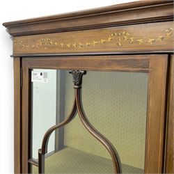 Edwardian inlaid mahogany display cabinet, projecting moulded cornice over two glazed doors, flanked by curved glazed sides and central arched panel with floral medallion, raised on square tapering supports with spade feet united by undertier