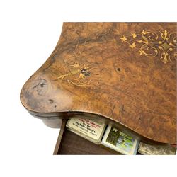 Victorian inlaid figured walnut games table, the serpentine fold-over top inlaid with scrolling foliate decoration, the top opens to reveal cribbage, backgammon and chess boards, single drawer over sliding storage well, on twin pillar supports united by double turned stretchers, on foliage carved out-splayed supports with brass and ceramic castors 