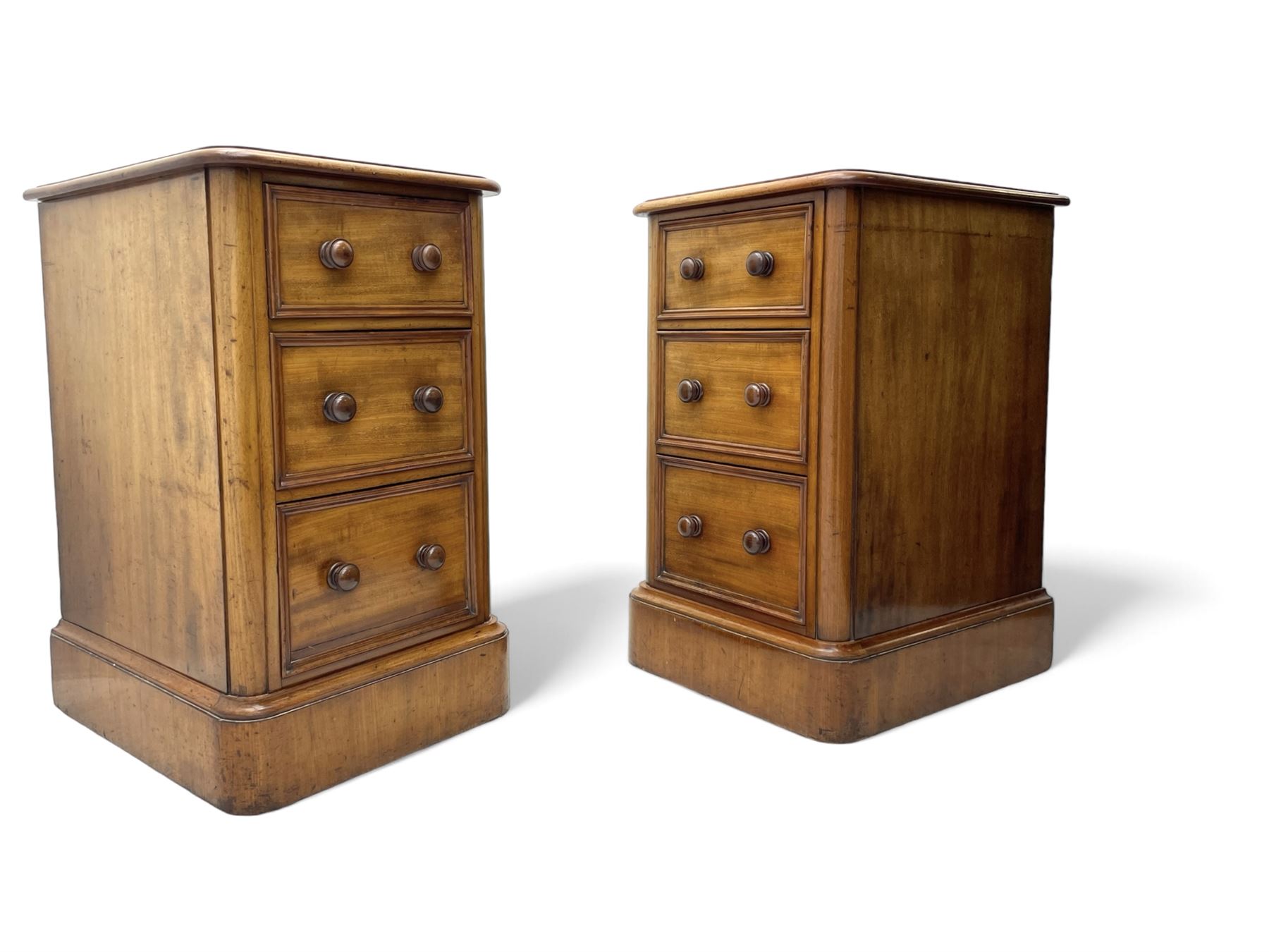 Pair of Victorian figured mahogany pedestal chests, rectangular form with rounded front corners, moulded top over three drawers with applied mouldings and turned handles, on moulded plinth base