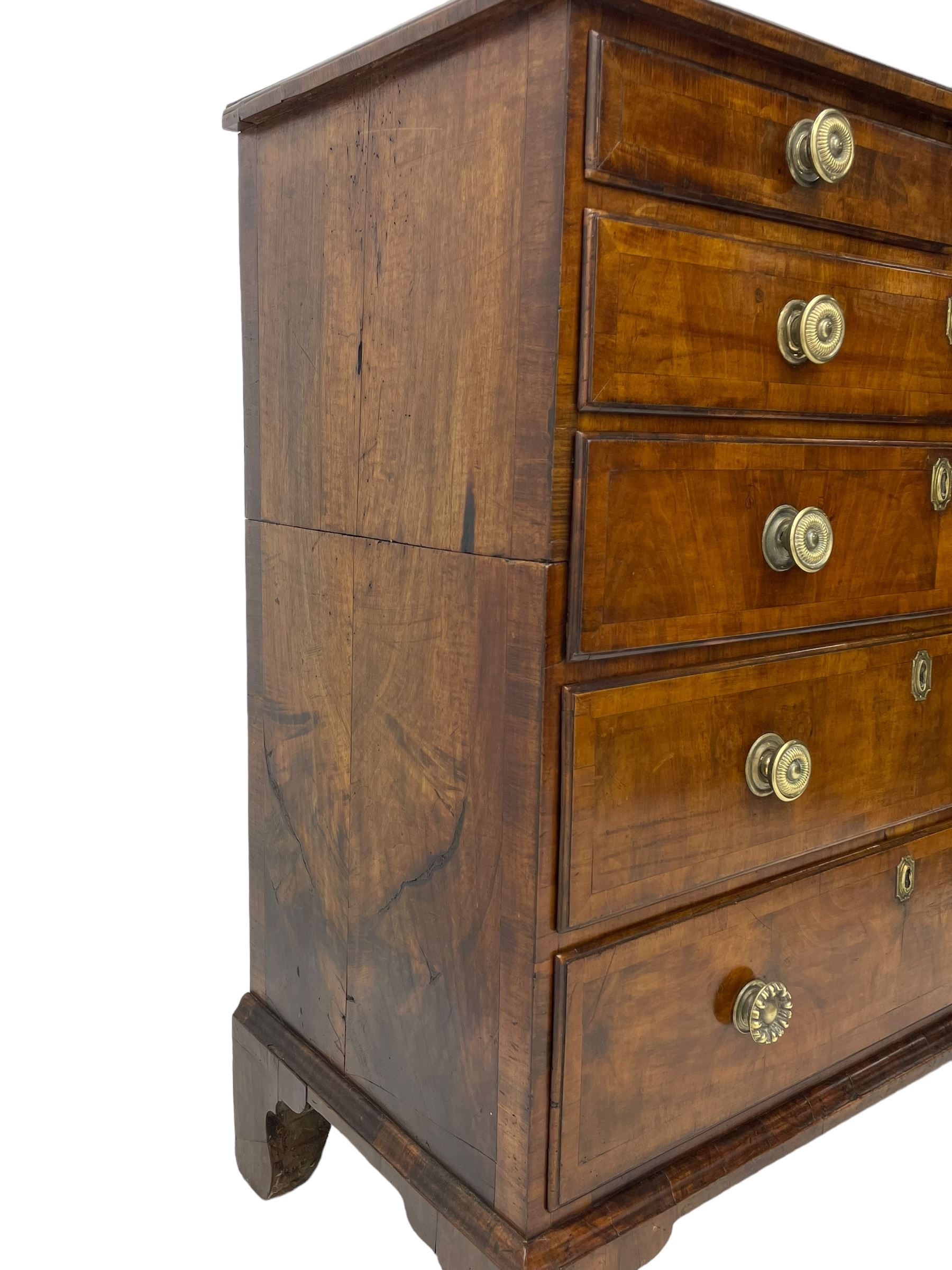 George I walnut chest, moulded rectangular top with book-matched veneers within crossbanding, fitted with two short over four long graduating drawers, moulded drawer fronts with brass handles, on bracket feet, the chest will split into two sections 