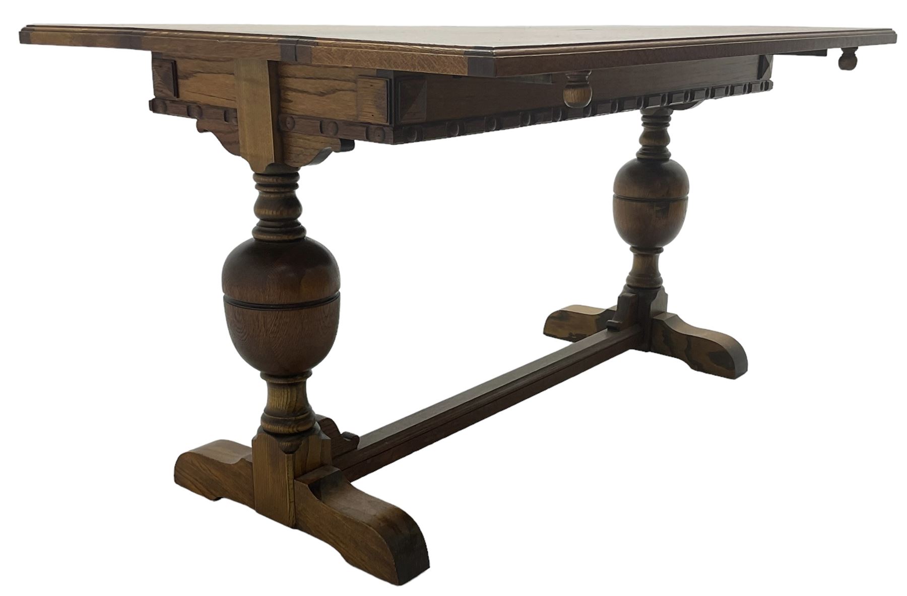 Early 20th century oak 'Ee-zi-Way one motion extending dining table', rectangular top over twin baluster end supports united by stretcher