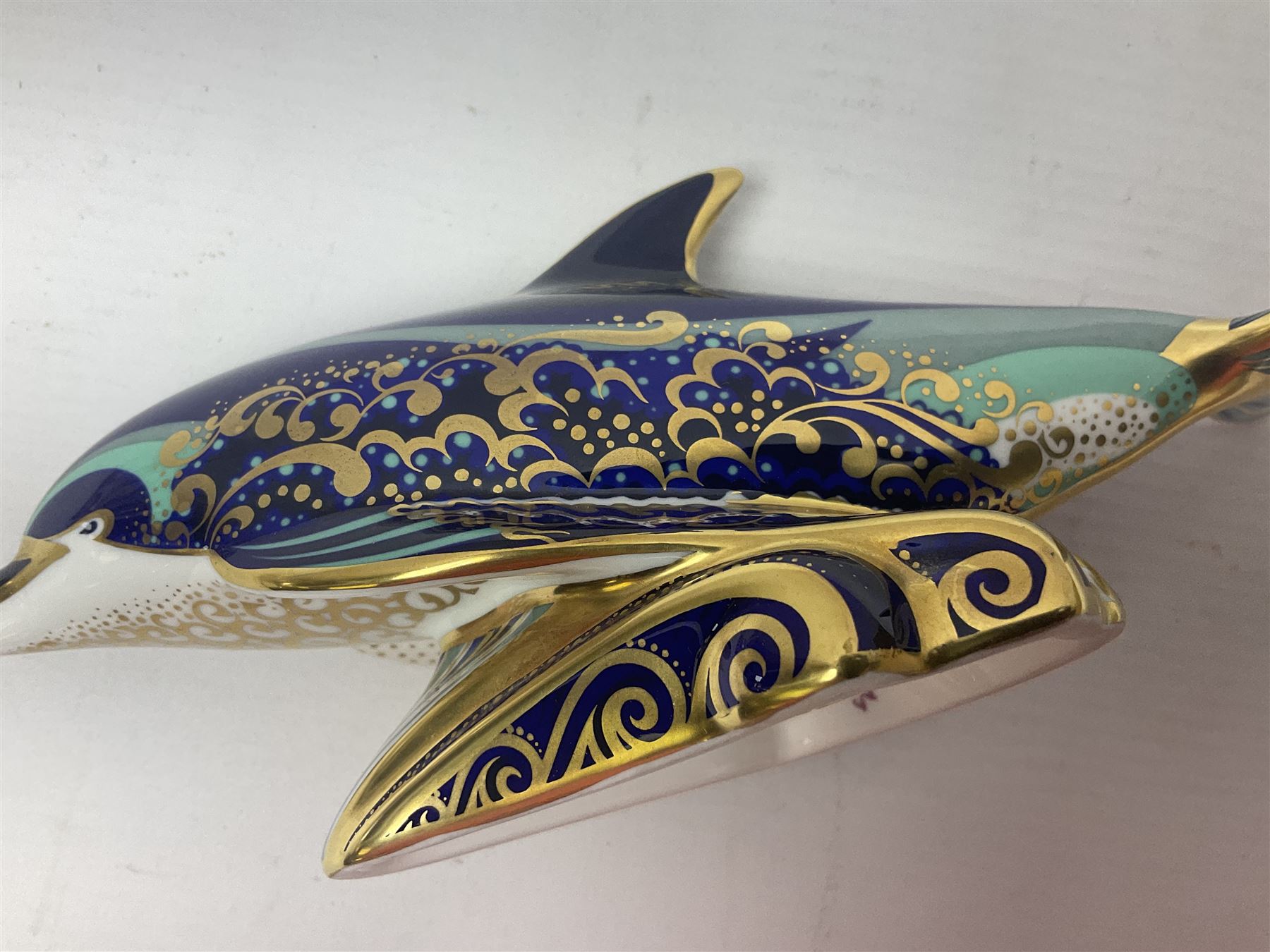 Three Royal Crown Derby paperweights, comprising Bottlenose Dolphin, Baby Bottlenose Dolphin and Striped Dolphin, all with gold stoppers 