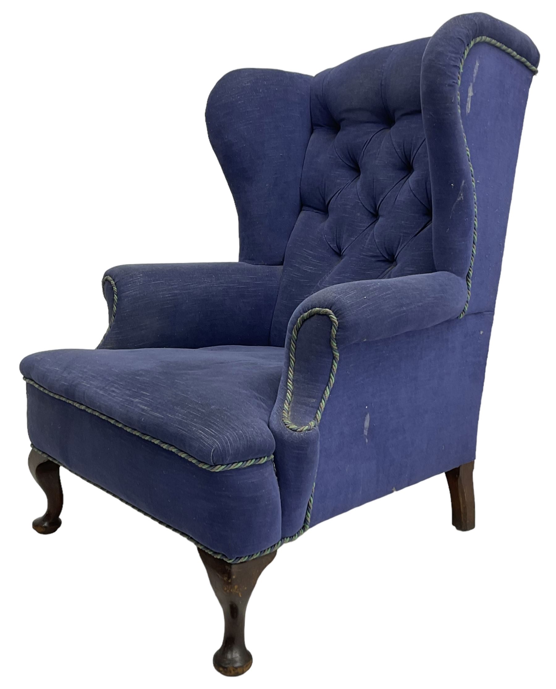 Early 20th century wingback armchair, upholstered in buttoned blue fabric, rolled and scrolled arms, on cabriole feet