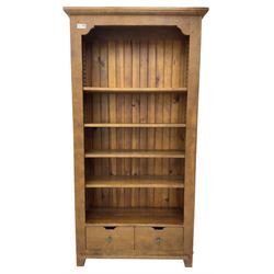 John Lewis - 'Bergerac' oak bookcase, projecting moulded cornice over four adjustable open shelves, two drawers to the base with cut-out handles, on square tapered supports