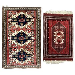 Persian Heriz red ground rug, the field with three large central medallions in indigo and ivory, border with geometric pattern within multiple guard stripes (119cm x 189cm); Persian Yomut crimson ground rug, central field with ivory medallion with geometric motifs, main border with geometric pattern within multiple guard stripes (88cm x 133cm)