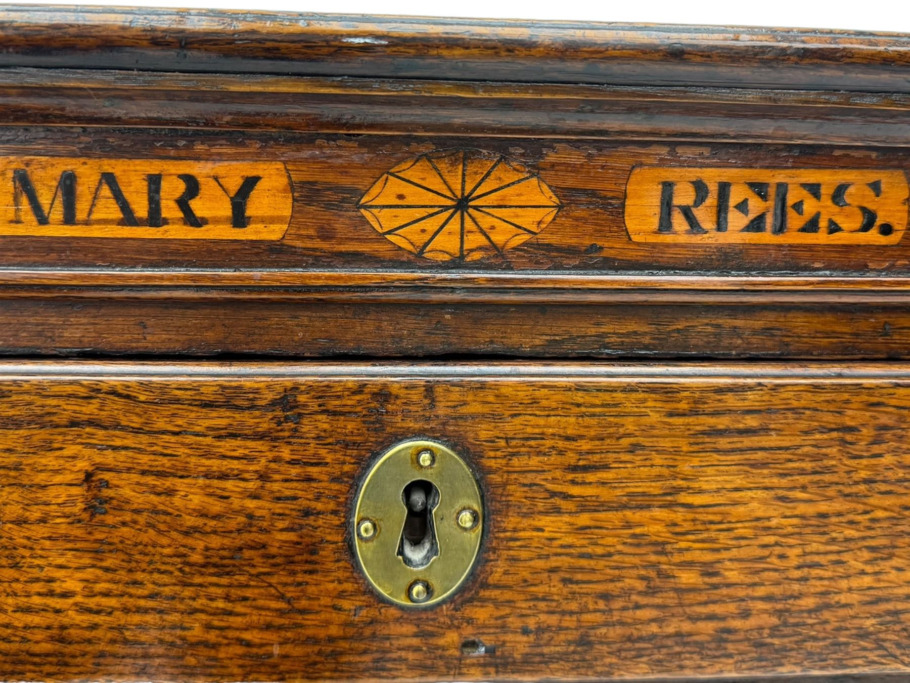 George III oak chest, rectangular top over frieze with inlaid with inscription panels 'Mary Rees' and fan motifs, frieze drawer over two short and three long graduating drawers, fitted with brass swan-neck handles and oval escutcheons, on bracket feet