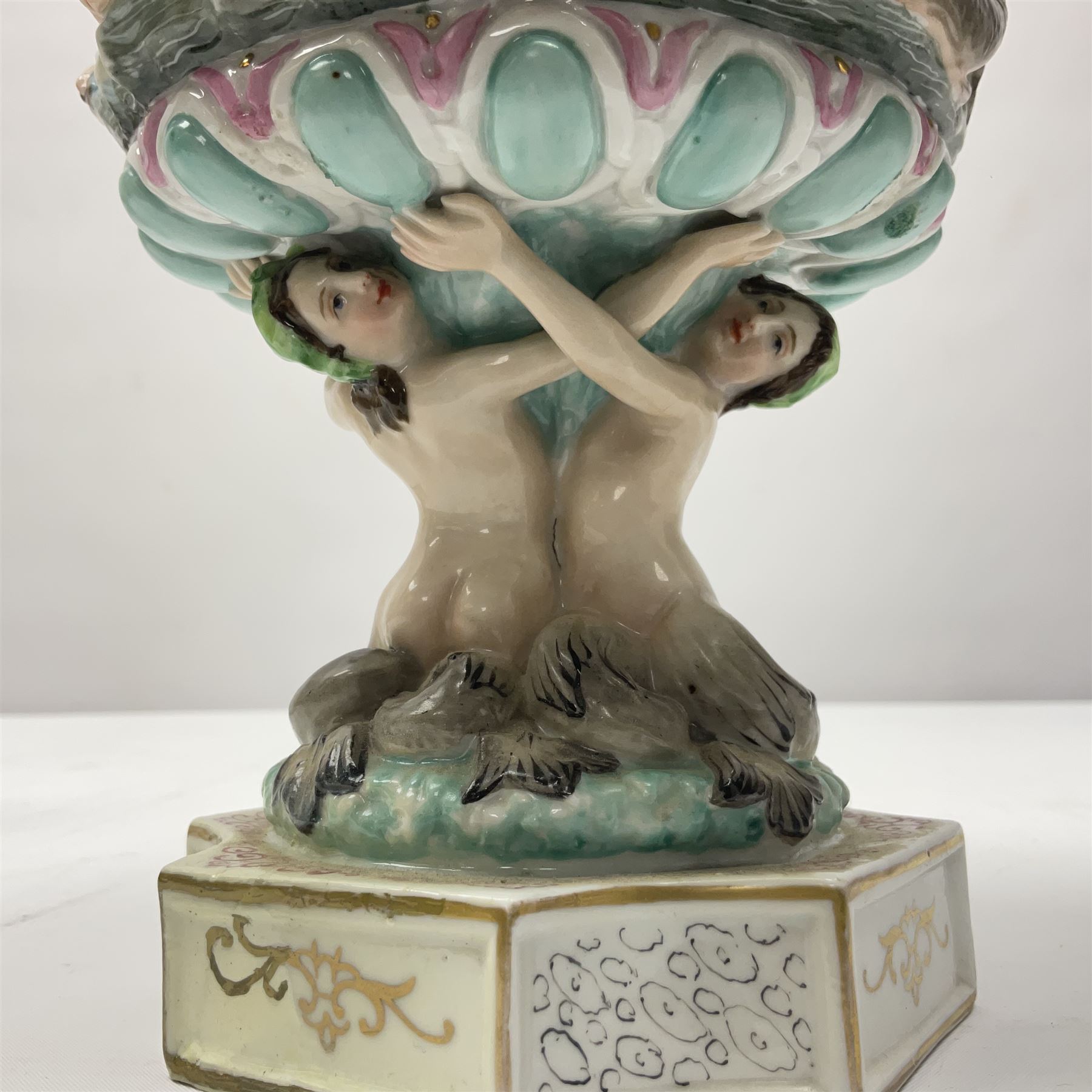 Early 20th century continental pedestal jar with cover, the bowl held aloft by four mermaids and decorated with putti playing instruments in a lake, the fluted domed cover topped with cherub playing a horn, H38cm