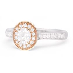 18ct white and rose gold diamond halo cluster ring, the principal oval cut diamond of approx 0.45 carat, with round brilliant cut diamond surround and diamond set shoulders, hallmarked, total diamond weight approx 0.70 carat