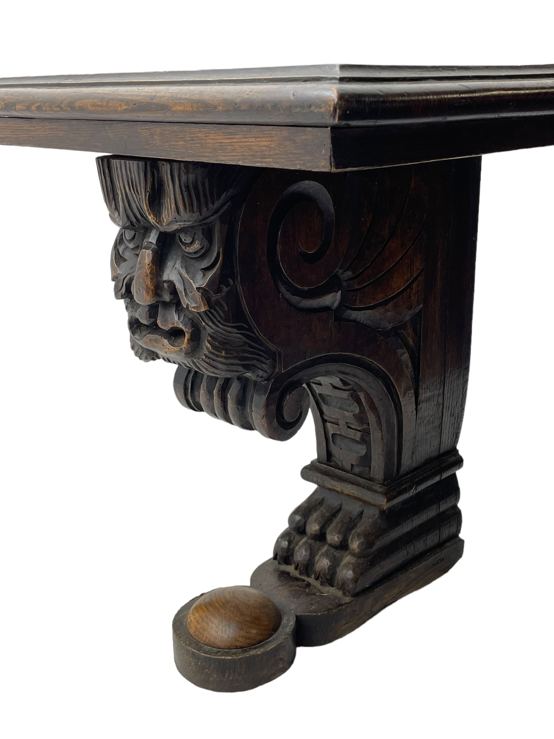 Victorian oak bench, moulded rectangular top, on mask and scroll carved corbel supports with paw feet, rectangular platforms with rounded terminals and applied roundel 