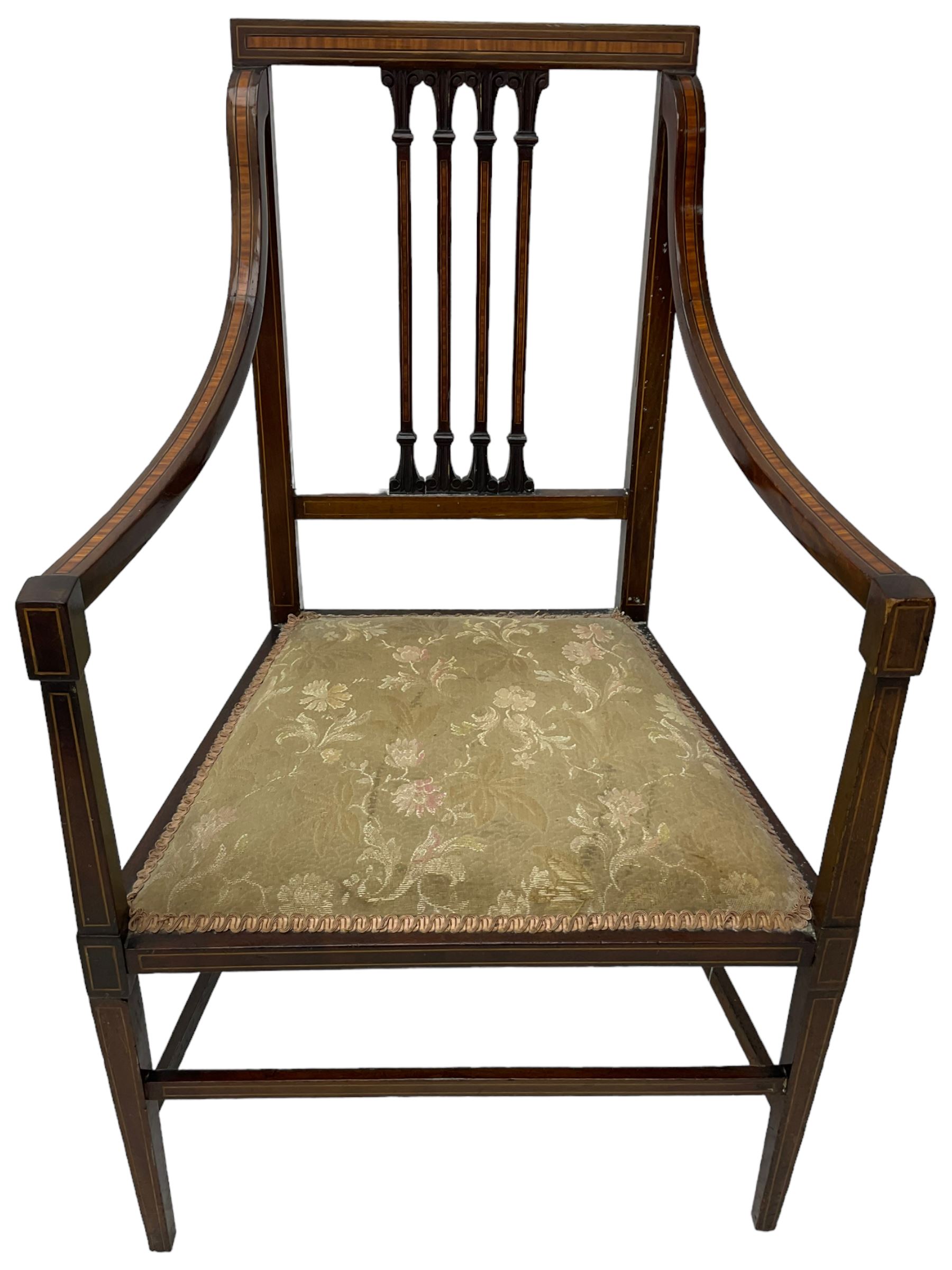 Edwardian satinwood inlaid mahogany elbow chair, the bar back over four vertical rails with foliate and scroll carved decoration, curved and down-swept arms, on square tapering supports united by stretchers 