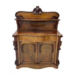 Mid-19th century rosewood chiffonier, raised back with scroll and leaf carved shaped pediment, serpentine top over drawer and double cupboard with scrollwork decoration, on shaped plinth base