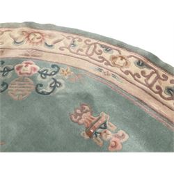 Chinese pale turquoise ground washed woolen rug, oval form decorated with bouquets of floral designs and Chinese characters, enclosed by a wide guard band