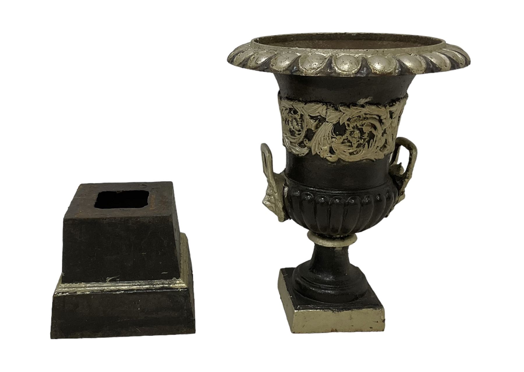 20th century cast iron Campana-shaped urn on plinth, with scrolling foliate relief decoration, in ebonised and silver painted finish