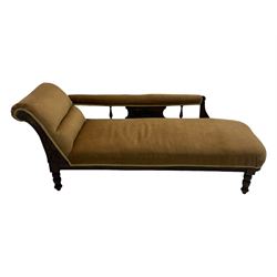 Late 19th century mahogany framed chaise longue, upholstered in tan fabric, featuring scrolled backrest with carved floral motifs, supported by turned legs