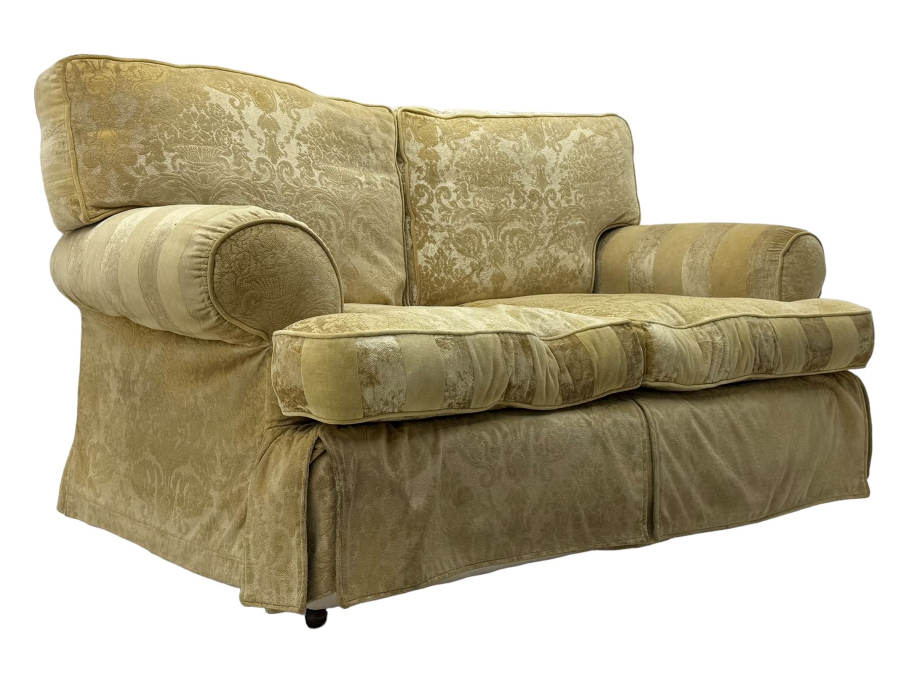 Contemporary two-seat sofa, upholstered in damask fabric with a pale gold floral pattern, rolled arms, loose back and seat cushions, on matching skirted base with concealed castors